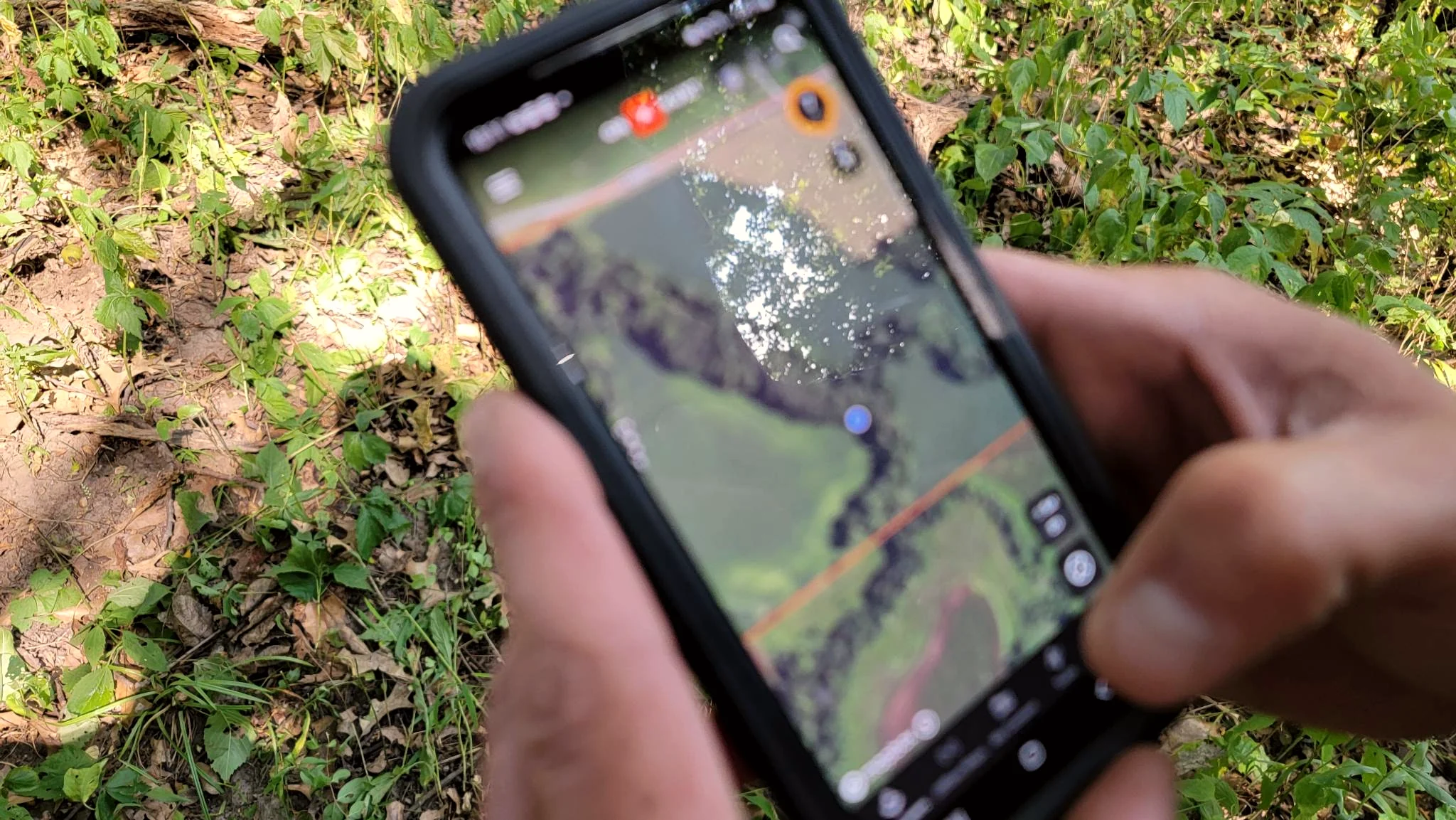 Scouting a property map on a phone at Bigger Bucks Outfitters in Illinois