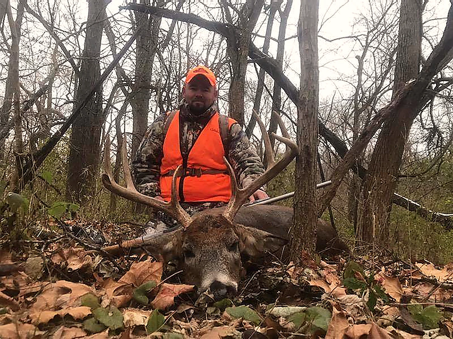 Hunters in blaze orange with an Illinois whitetail buck at Bigger Bucks Outfitters